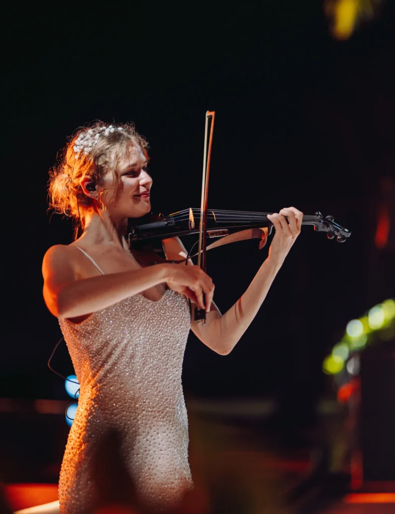 Girl in elegant couture playing the violin at a wedding