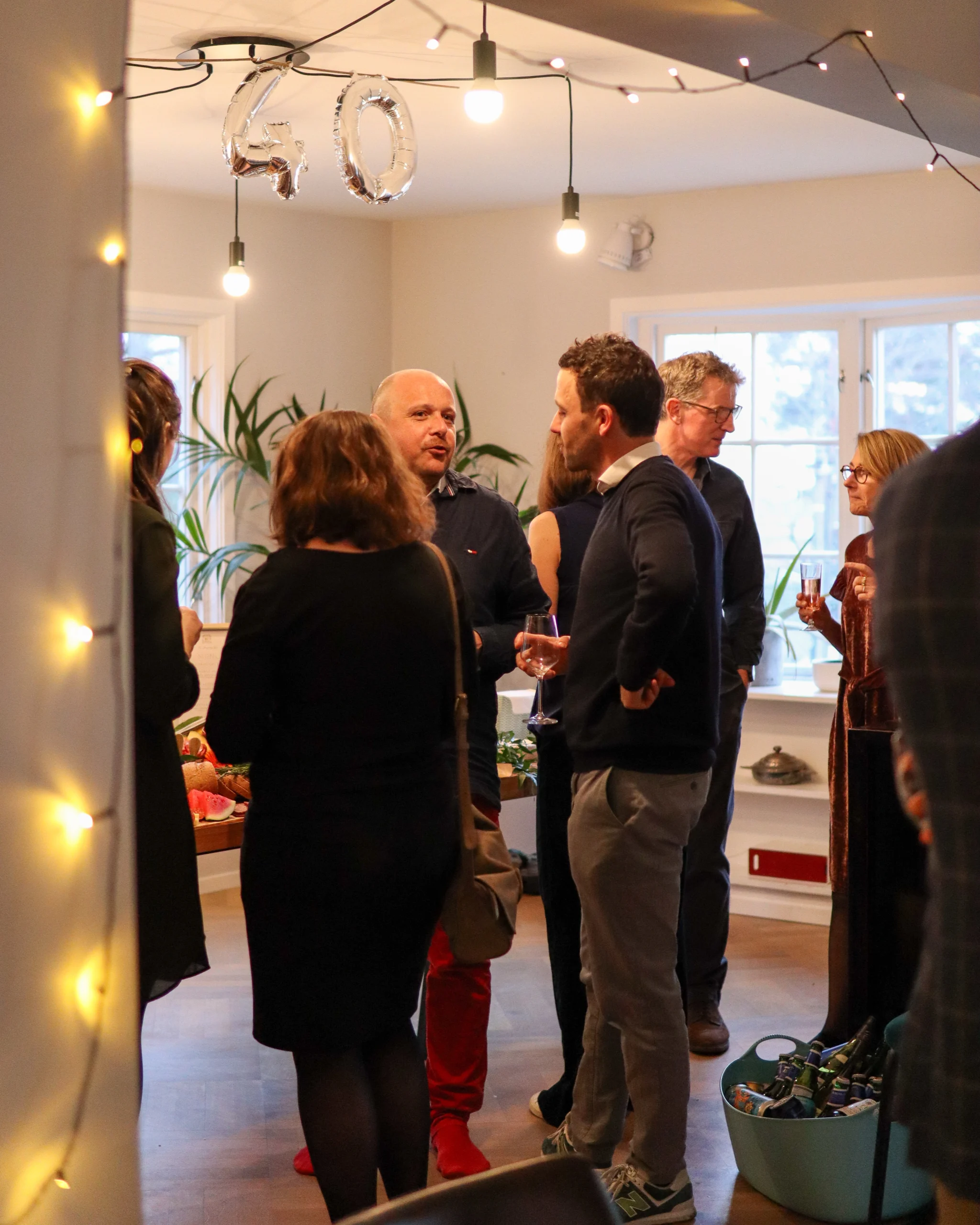 Folk som chatter med hverandre på en liten hjemmebursdagsfest.