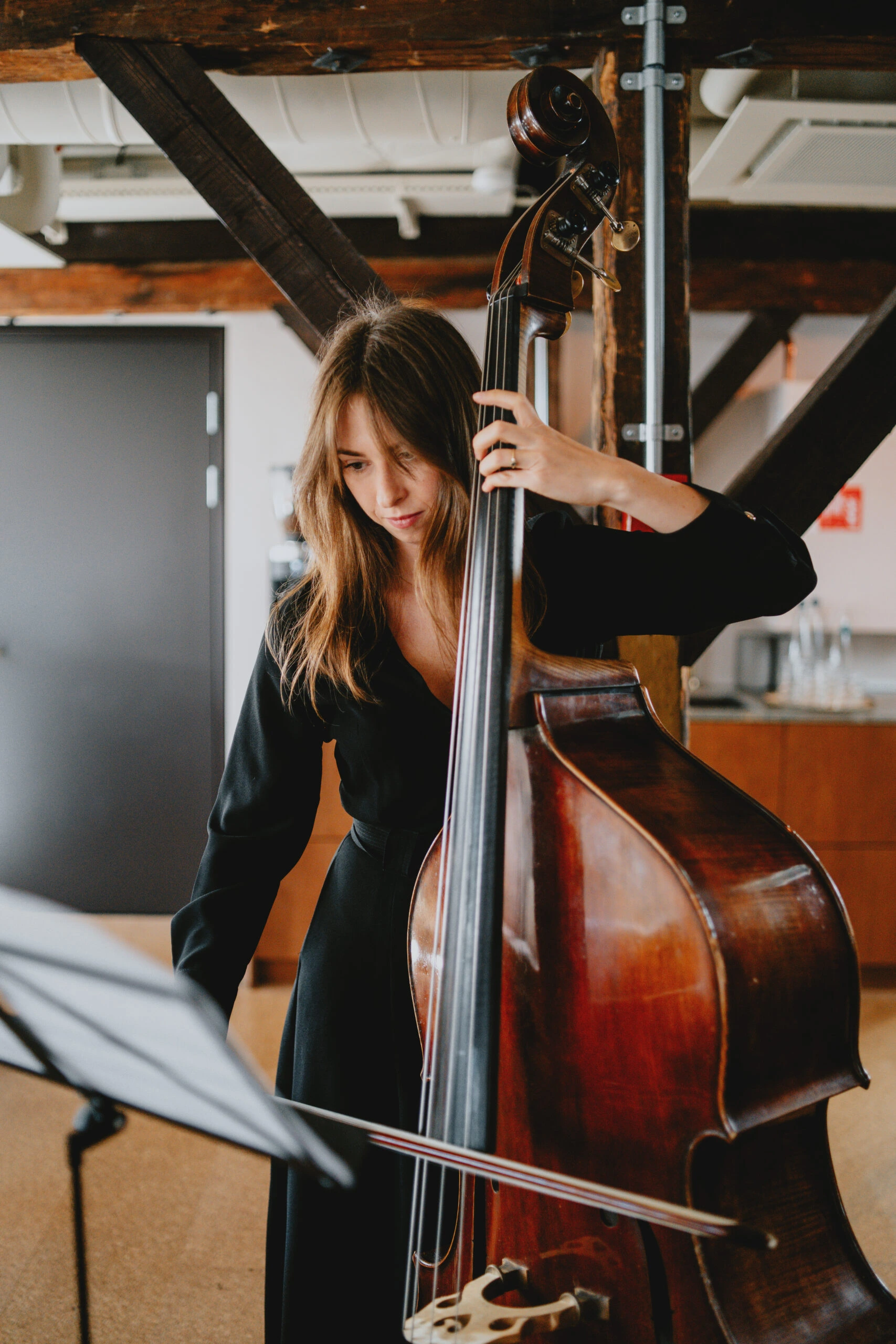 A girl in a black dress playing the cello at a memorial service.