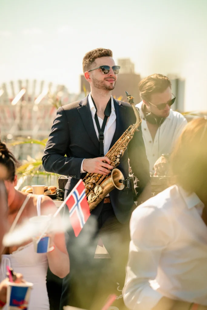 A man playing the saxophone while performing with a band at a wedding.