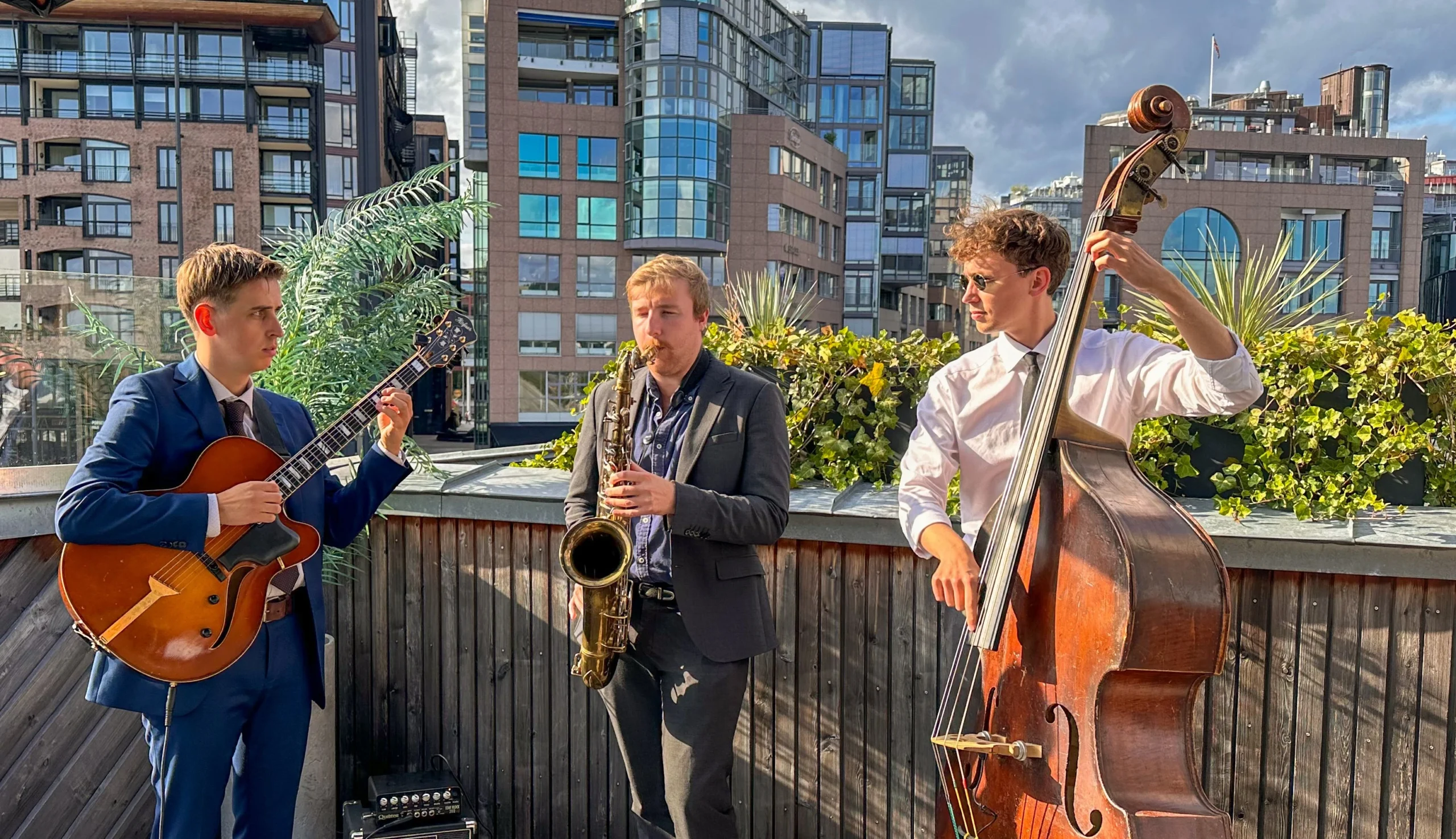 A trio performing live music at a private event on a rooftop.