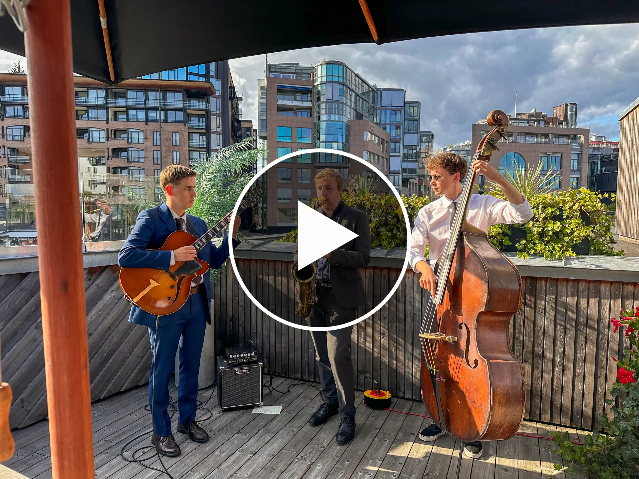 A trio performing live music at a private event on a rooftop in Norway.