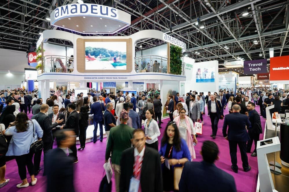Visitantes recorriendo los stands de una feria internacional de turismo y tecnología.